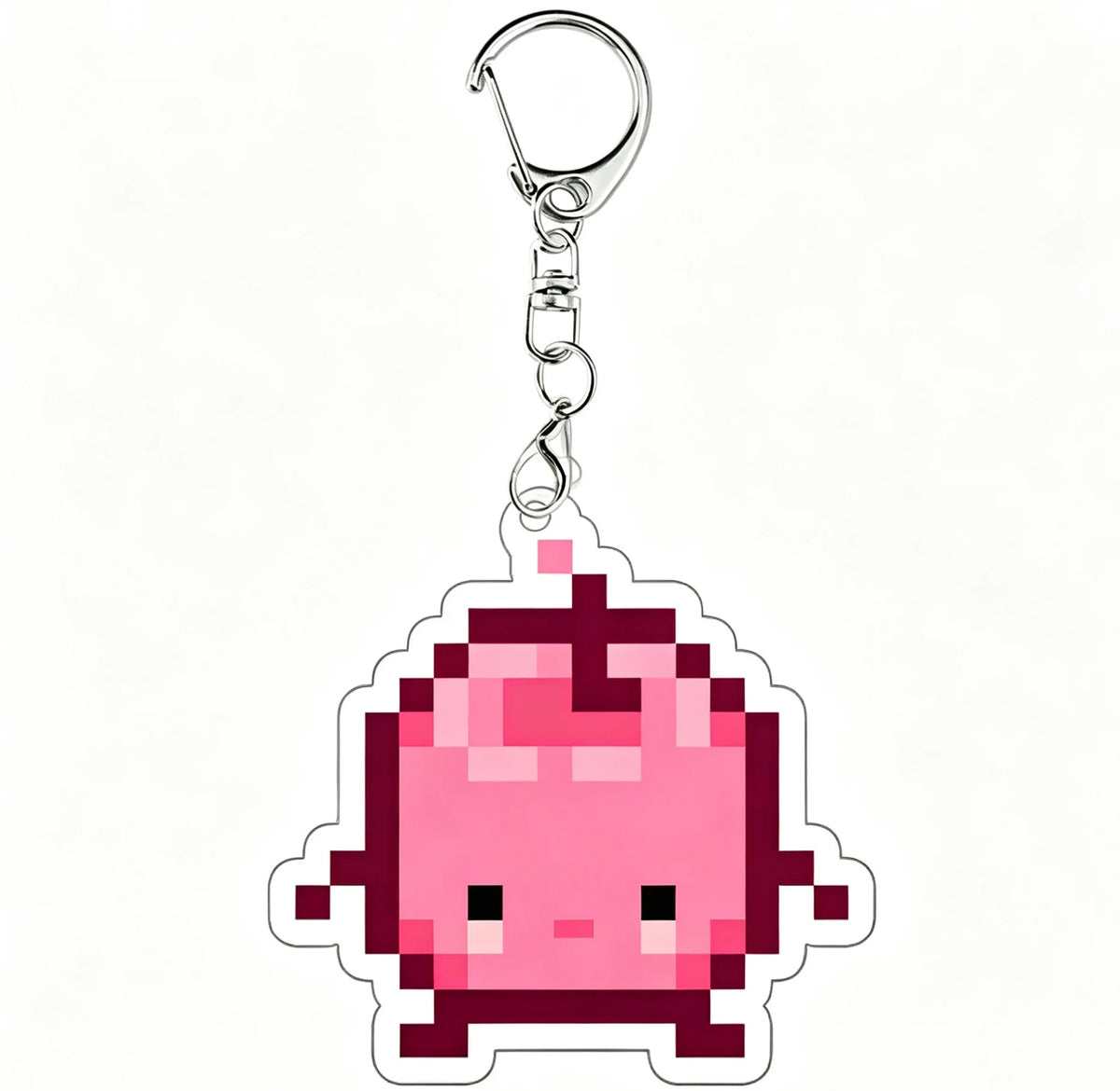 A pink pixel art charm of a Junimo character attached to a silver keychain ring.