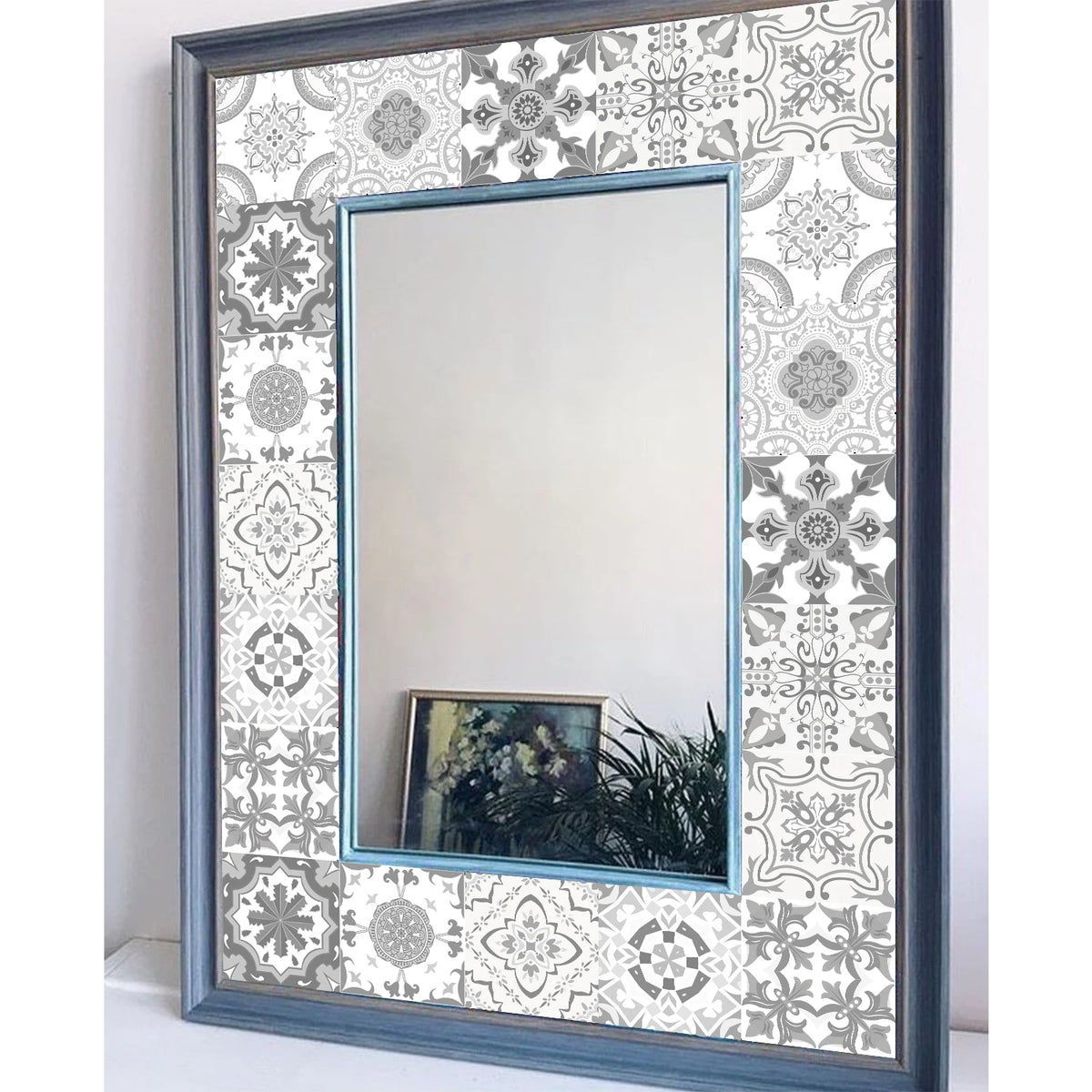 A rectangular mirror framed in dark blue, featuring a decorative patterned border and reflecting the room.