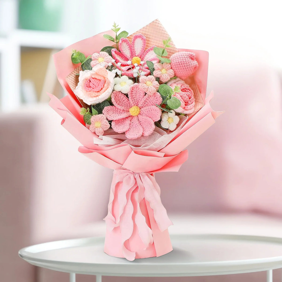 A bouquet of handcrafted crochet tulip flowers in various shades of pink and green, wrapped in pink paper.