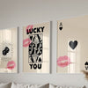 Three framed art prints featuring pink lips and black text on a light background