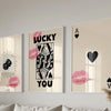 Three framed art prints featuring pink lips and black silhouettes of a woman and a heart