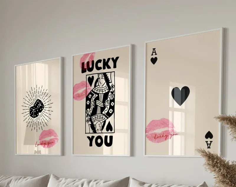 Three framed art prints featuring pink lips and black silhouettes of a woman and a heart
