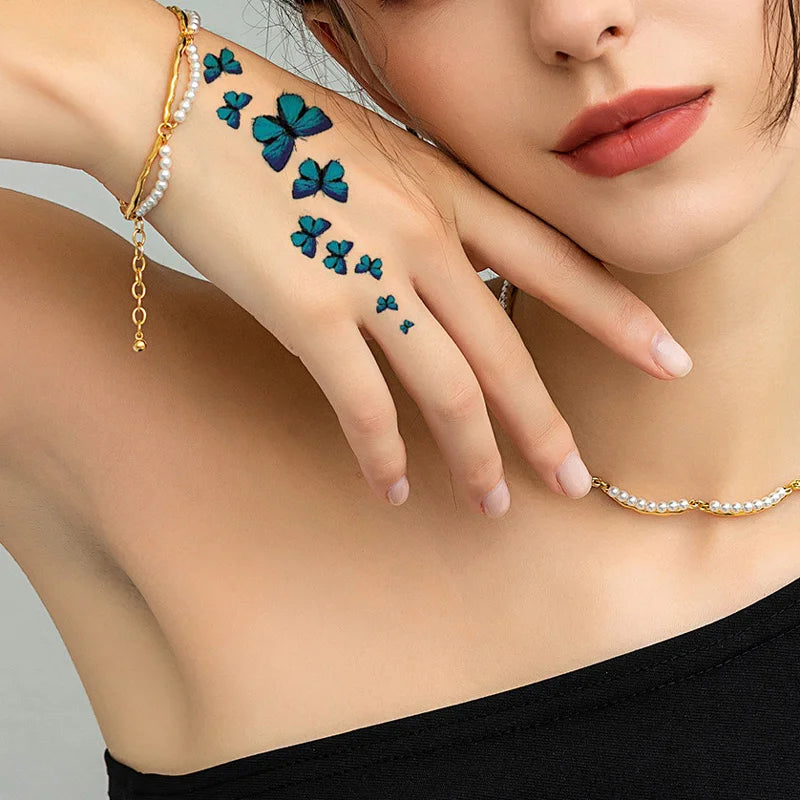 Hand with temporary blue butterfly body art stickers on the forearm and wrist
