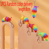 A colorful, striped fidget slug toy is displayed on a wooden staircase and hanging from a hook.
