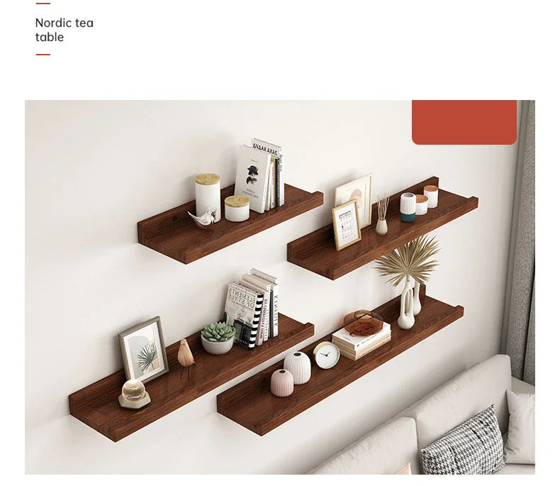 A set of natural wood floating shelves mounted on a white wall displaying various decorative items.