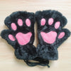 A pair of black furry cat paw hand warmers or costume accessories with pink pads.