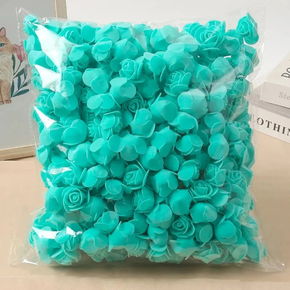 A clear plastic bag filled with bright turquoise artificial rose foam flowers for DIY decoration.