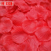 A close-up of vibrant red silk rose petals used for weddings and events.