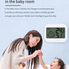 A woman is monitoring a baby in a crib using an intimate small housekeeper device to ensure healthy growth.