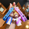 A hand holds a silicone keychain featuring Jesus with a colorful strap and gold ring.