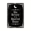 A black metal tin sign featuring a crescent moon and the text She Herself is a Haunted House in an ornate gothic style.