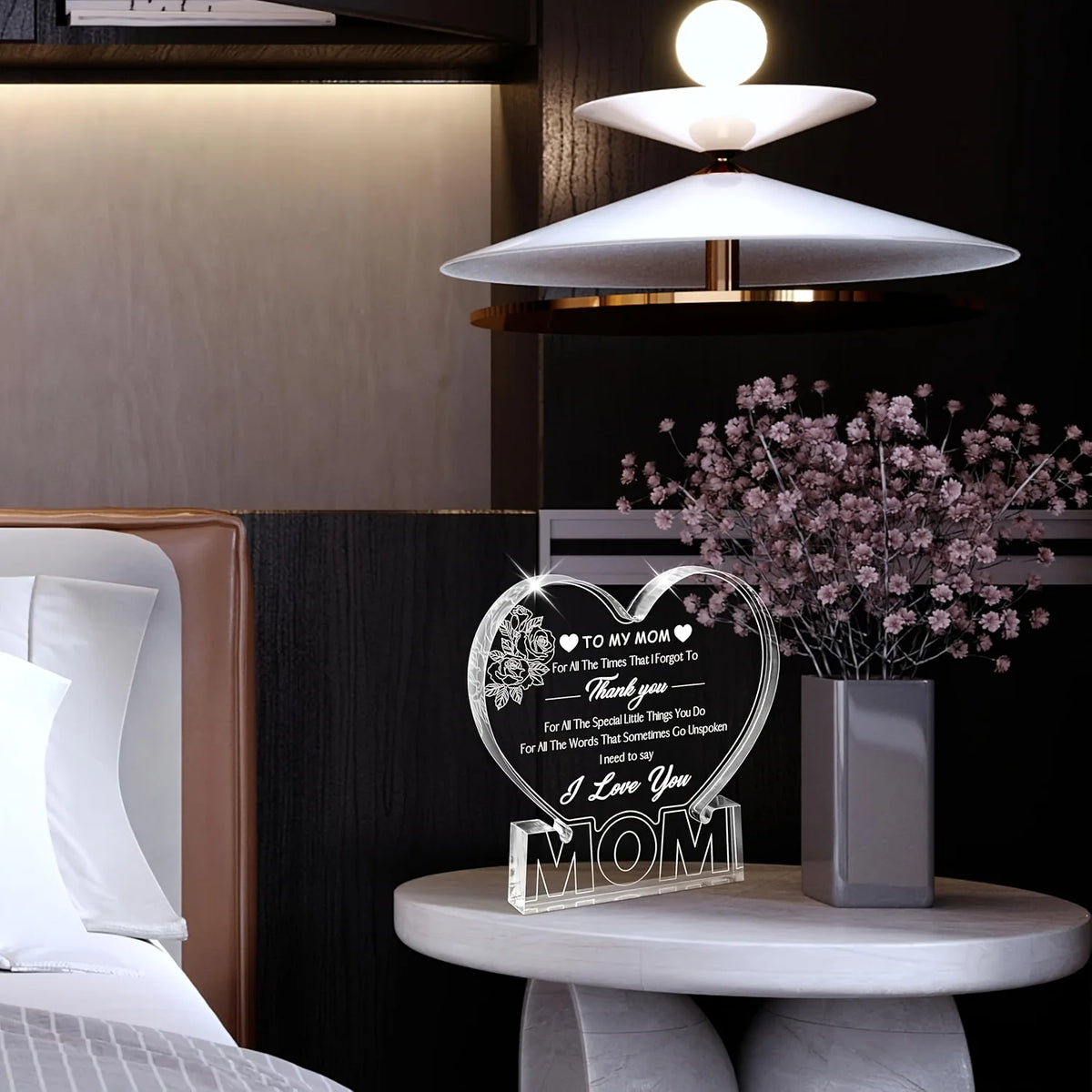 Clear acrylic heart plaque with floral design for a mom gift displayed on a bedside table.