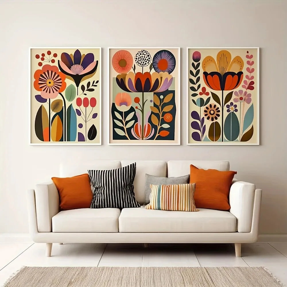 A set of three framed floral canvas prints featuring colorful Scandinavian folk art designs on a light wall.