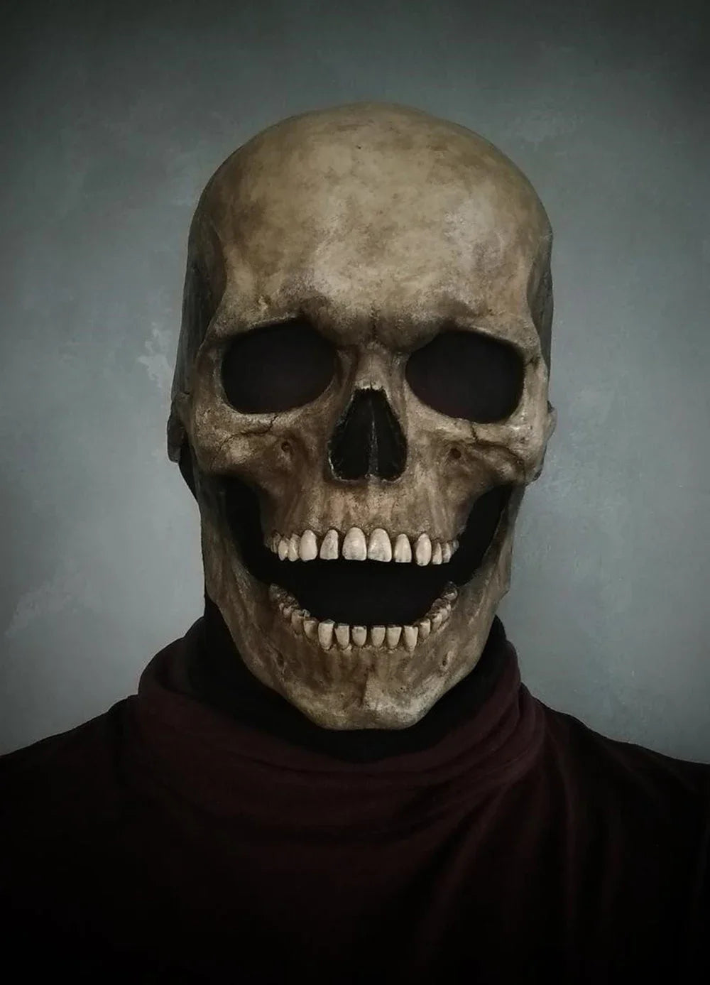 A realistic latex skull cosplay mask displayed against a gray background.