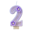A purple sparkling number two candle decorated with small purple flowers.