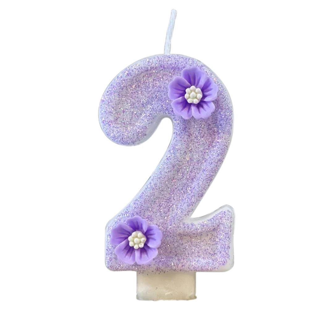 A purple sparkling number two candle decorated with small purple flowers.