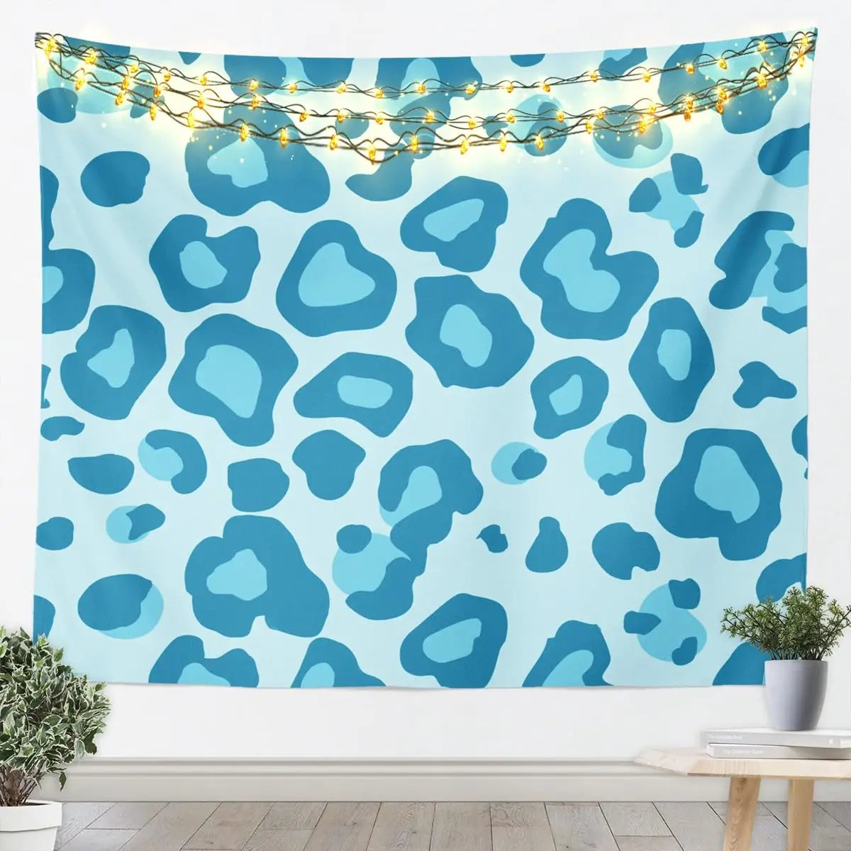 A light blue leopard print tapestry wall hanging decorated with string lights.