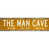 A rectangular, weathered yellow metal street sign with the text THE MAN CAVE EST. 1997.