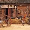 A rustic wooden barn door with a sign reading SMALL BARN and various western tools and equipment.