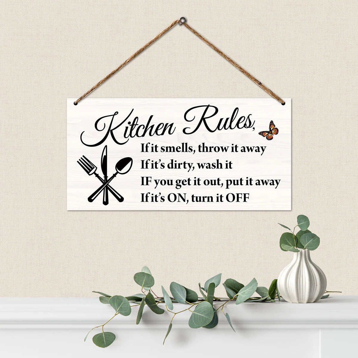 A white wooden hanging sign with black script listing kitchen rules such as throwing away smelly items and turning off applia