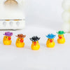 Five glow-in-the-dark resin duck figurines with colorful hats arranged on a white surface.