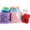 A collection of artificial foam rose flowers in various colors including blue, purple, pink, orange, and gray.