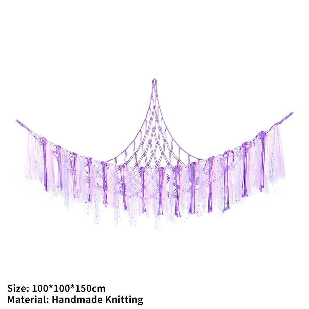 A purple handmade knitted storage hammock for toys and plushies with dangling strands.