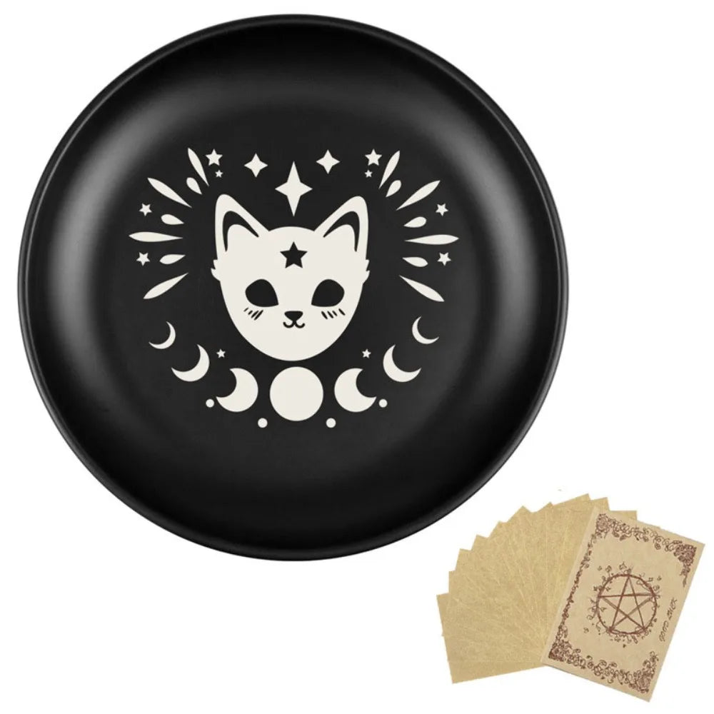 Assiette en céramique noire avec une silhouette de visage de chat blanc entourée d'étoiles et de lunes crescentes.