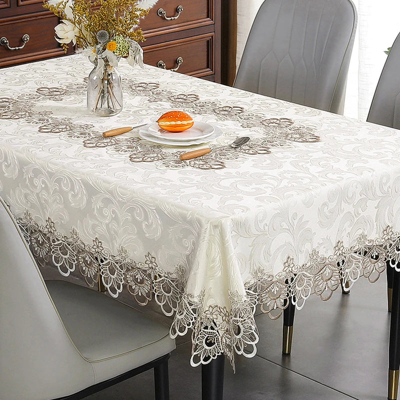 White embroidered lace tablecloth set for a dining table with a floral rectangle design