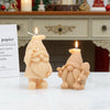 A small, light orange silicone candle mold shaped like a gnome with a honeycomb hat and a lit wick.