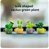 A set of four green resin cactus plants shaped like animals sitting in yellow and gray mugs for home decor.