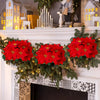A festive holiday display featuring artificial poinsettia flowers in red and green garlands on a white mantelpiece.