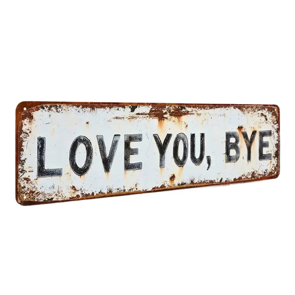 A rectangular, weathered metal sign with the text LOVE YOU BYE stamped into it.