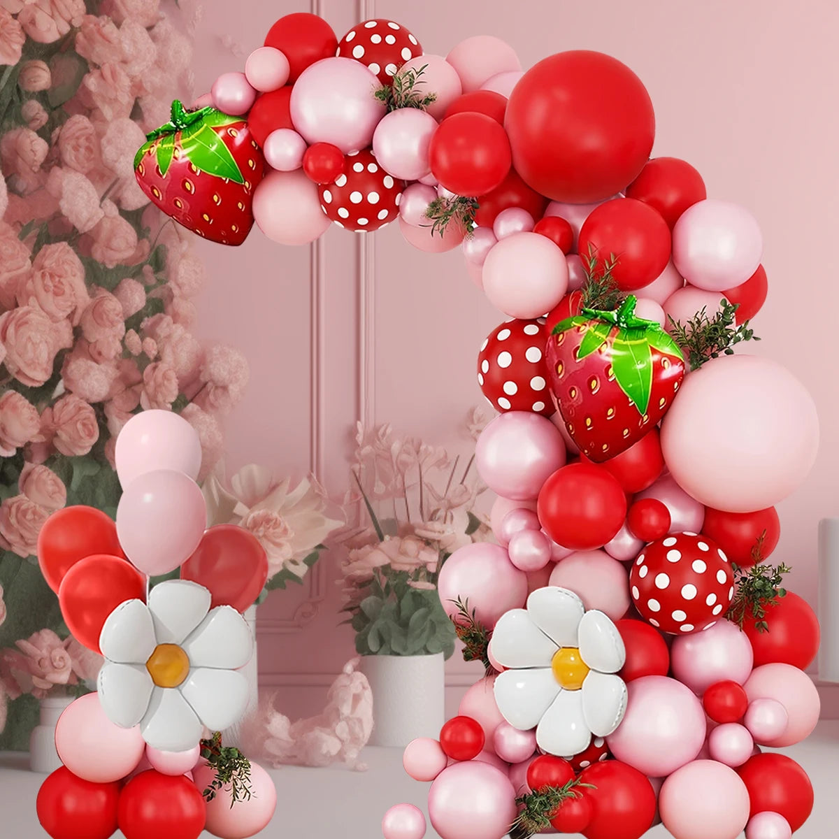 A pink and red balloon arch wreath featuring strawberries and foil accents.