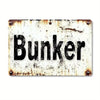A distressed, vintage metal tin sign with the word Bunker stamped in black text on a white background.
