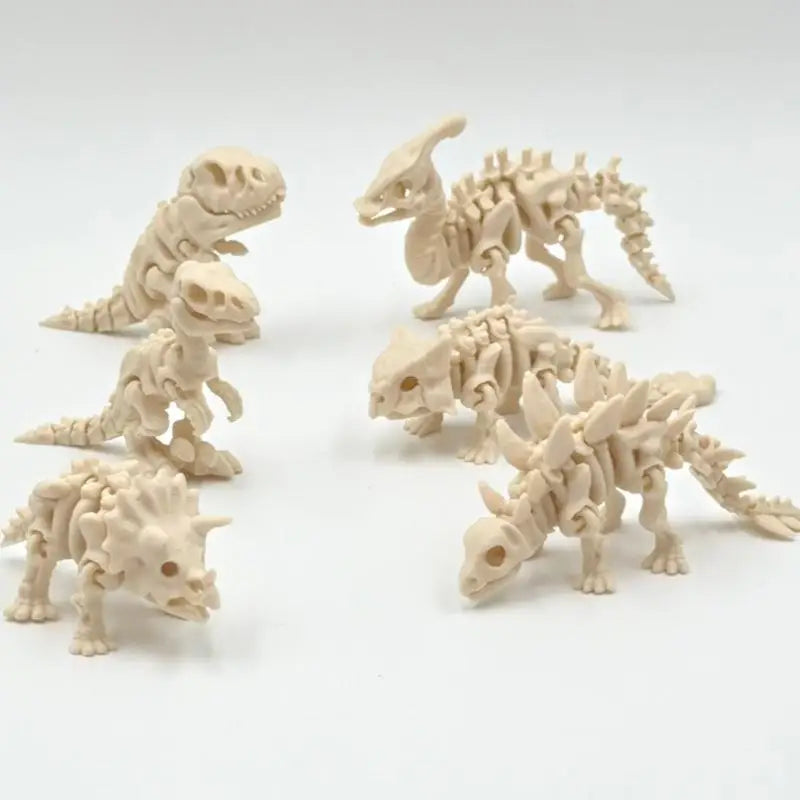 A set of three 3D printed dinosaur skeletons in a light beige color displayed against a white background.