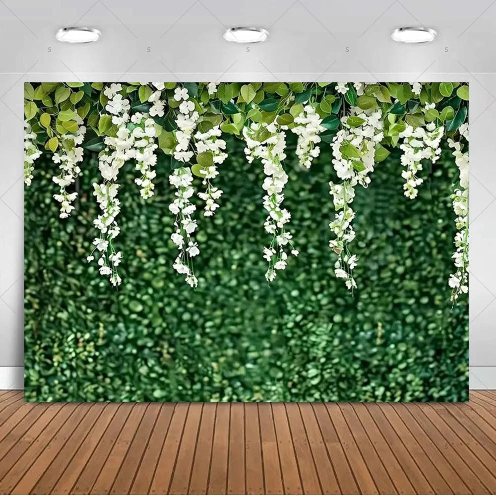 A lush green tropical palm leaf backdrop decorated with cascading white flowers and leaves.