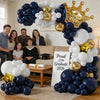 A balloon arch display featuring navy blue, white, and gold balloons in a crown shape for a graduation celebration.