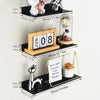 A set of floating metal wall shelves displaying various decorative items like a white cat, flowers, and a glass vase.