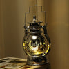 A silver LED lantern night light with a decorative lid and star patterns, emitting a warm glow.