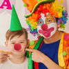 A young boy is posing with a classic red clown nose, soft foam ball, for costumes and parties.