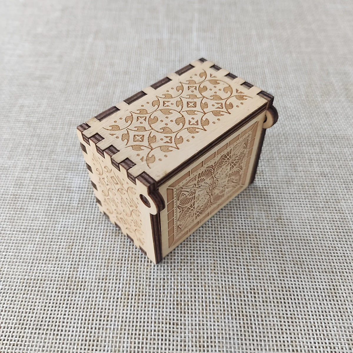 Antique carved wooden music box with intricate floral patterns on the lid and body