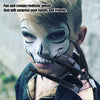 A young boy wearing realistic white and black clown makeup and articulated skeleton hand gloves.