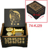 A wooden box containing a brass music box with a lion design and decorative patterns.