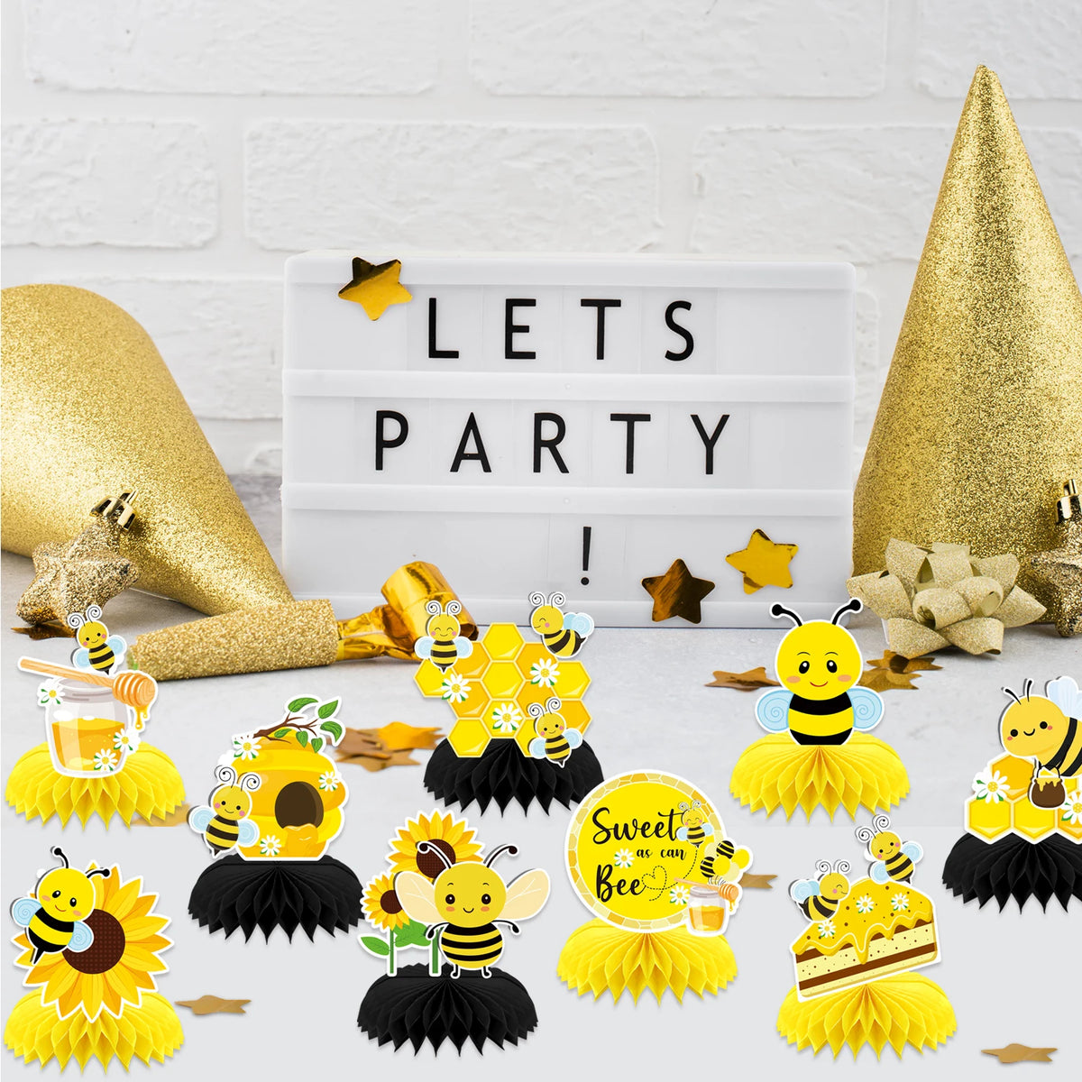 Ein Set gelber und schwarzer Papier-Centerpieces mit Bienen, Sonnenblumen und einem weißen Schild mit der Aufschrift „Lets Pa