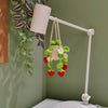 A white desk lamp with a hanging plant basket featuring green leaves and red strawberries