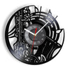 A black vintage vinyl record wall clock featuring intricate design and a white face.