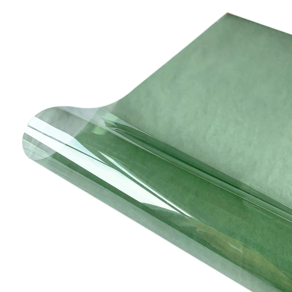 A roll of decorative stained glass window film in a translucent green color.