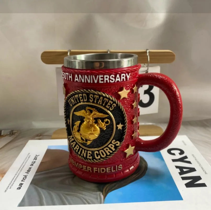 Taza de café roja con temática militar, letras doradas y un diseño de estrella.