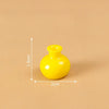 A small, bright yellow resin vase with a round body and a flared opening.